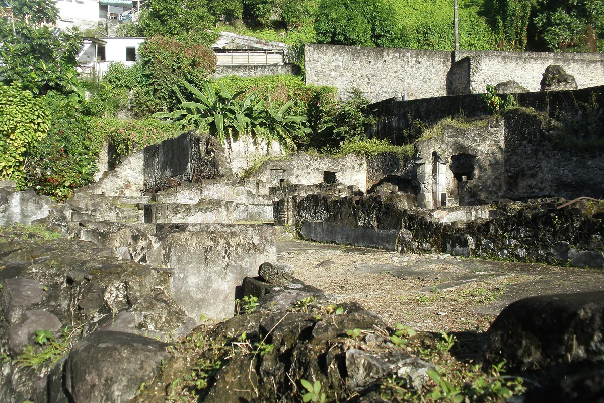 Ruines de l’ancienne prison de Saint-Pierre entourées de végétation tropicale